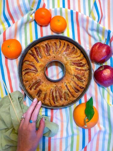 una persona è in piedi accanto a una torta su un tavolo di Policlinico Apartments a Catania