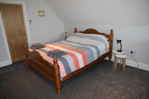 a bedroom with a bed and a table with a lamp at Superb Stokesby Barn Apartment - Norfolk Broads & Norwich in Stokesby