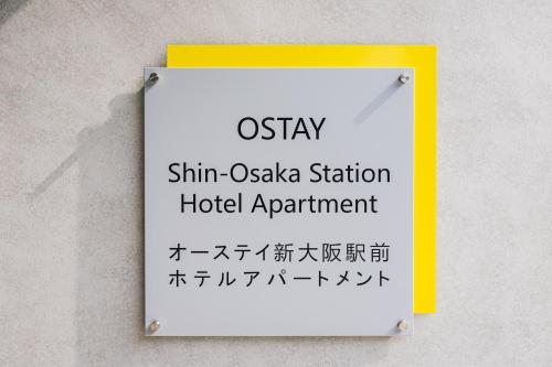 a sign on a wall with asian writing on it at Ostay Shin-Osaka Hotel Apartment in Osaka