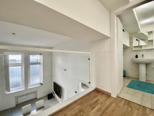 an empty living room with white walls and wood floors at Future Apartments in Milan