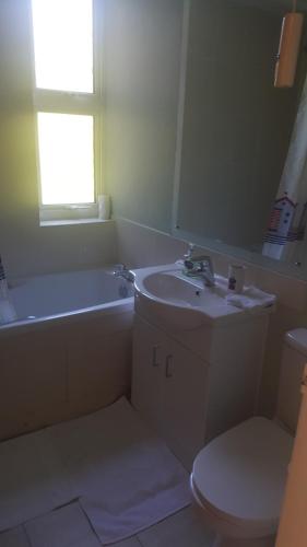 a bathroom with a sink and a tub and a toilet at 38 Cambanks 2 double bedroom apartment in Cambridge