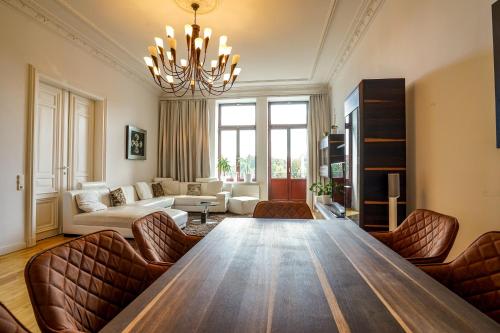 ein Wohnzimmer mit einem großen Holztisch mit Ledersesseln in der Unterkunft **Traumhafte City-Wohnung // 120qm // 4-Räume** in Leipzig