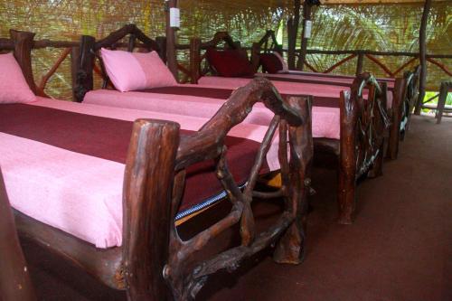 a row of wooden beds in a room at YalaWay Nature Villa in Tissamaharama
