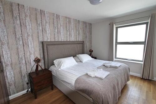 Corbiere Phare Apartments في سات بريلاد: غرفة نوم عليها سرير وفوط