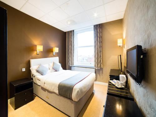 a hotel room with a bed and a tv at OYO Hotel Majestic in Barrow in Furness
