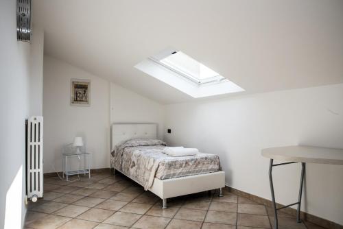 um quarto branco com uma cama e uma clarabóia em Residenza Meeting em Verona