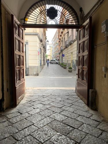 an alley with an open door with a person walking down the street at Mazzini Privè in Caserta