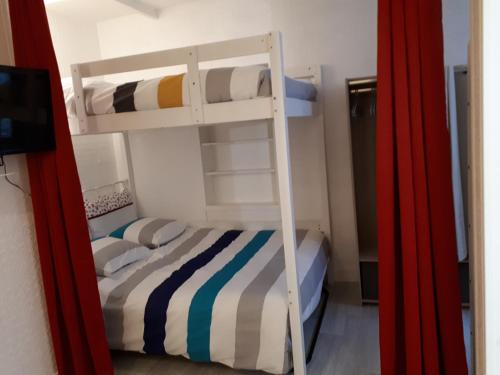 une chambre avec un lit superposé avec une échelle dans l'établissement le petit dieppois, à Dieppe