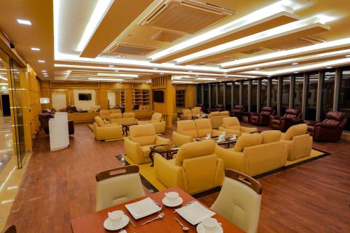 a large room with yellow chairs and tables and chairs at Royal Swiss Lahore in Lahore