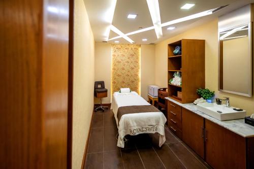 a hospital room with a bed and a sink at Royal Swiss Lahore in Lahore