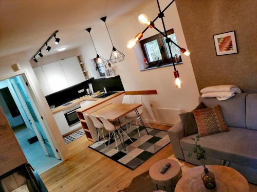 a living room and kitchen with a couch and a table at Apartments FRUTIS in Bjelašnica