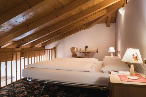 una camera con un grande letto in una stanza con soffitti in legno di Apparthotel Sellaronda ad Arabba