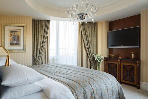 a bedroom with a large bed and a television at InterContinental - Kyiv, an IHG Hotel in Kyiv