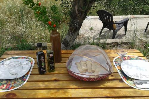 a picnic table with plates and wine glasses and food at Palheirinho in Zimbreira