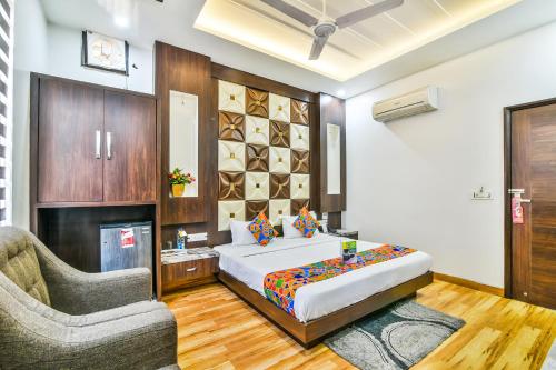 a bedroom with a bed and a couch and a chair at FabHotel Aman Residency Sharifpura in Amritsar