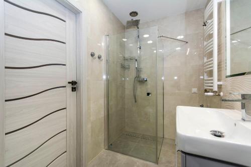 a bathroom with a shower and a sink at Apartament Amber z garażem moj-sopot pl in Sopot