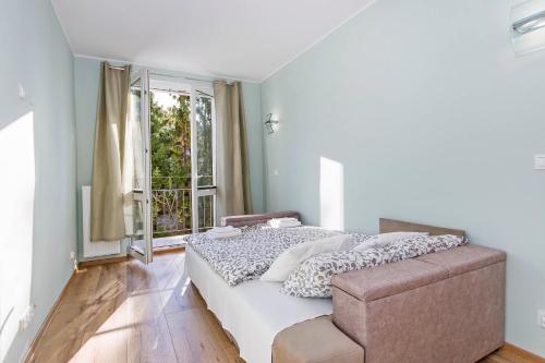 a bedroom with a bed and a large window at Apartament Amber z garażem moj-sopot pl in Sopot