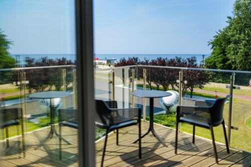 a balcony with chairs and tables and a view of the ocean at Ultra Marine by Zdrojowa in Kołobrzeg
