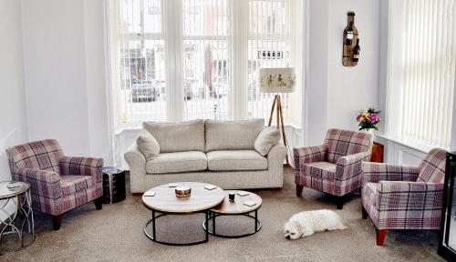 a living room with a couch and two chairs and a table at Avenue Guest House in Blackpool