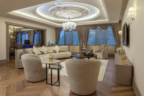 a living room with a couch and chairs and a chandelier at Kaya Izmir Thermal & Convention in Izmir