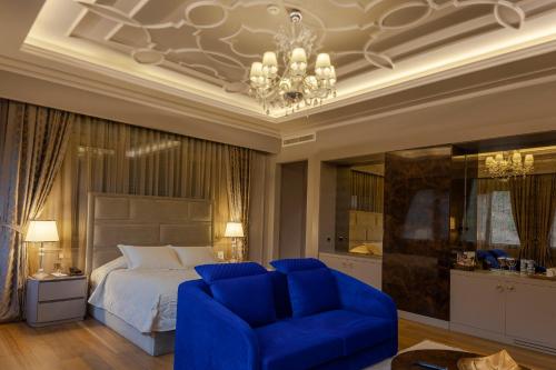 a bedroom with a bed and two blue chairs at Kaya Izmir Thermal & Convention in Izmir