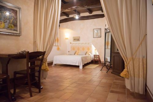 a bedroom with a bed and a desk in it at Hotel Anticos Palathos in Orosei