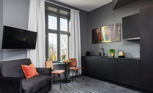 uma sala de estar com um sofá e uma mesa em Hotel Filip em Oslo