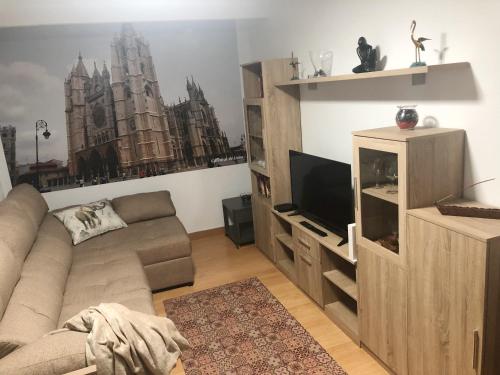 ein Wohnzimmer mit einem Sofa und einem TV in der Unterkunft Apartamento céntrico en León in León