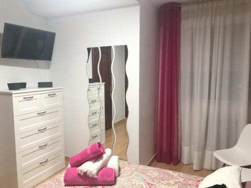 a bedroom with a dresser and a bed with pink pillows at Apartamento céntrico en León in León
