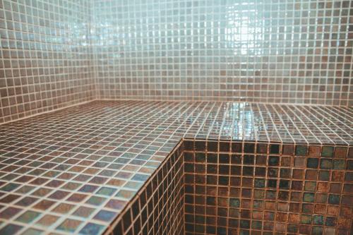 a bathroom with a tiled floor with at Terres de France - Le Domaine de Bacchus in Saint-Christol