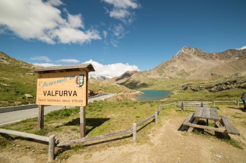 a sign on the side of a road in the mountains at Al Baitin - Charme & Nature - in Santa Caterina Valfurva