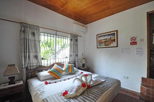 um quarto com uma cama grande e uma janela em Acquario Guesthouse em Praslin