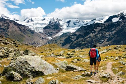 a man with a backpack standing on a mountain looking at glaciers at Al Baitin - Charme & Nature - in Santa Caterina Valfurva