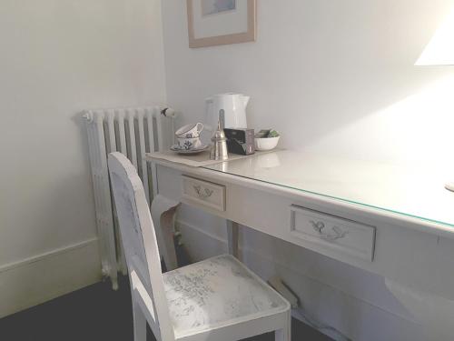 a white desk with a chair and a counter top at Les Chambres de LOUIS in Le Chesnay