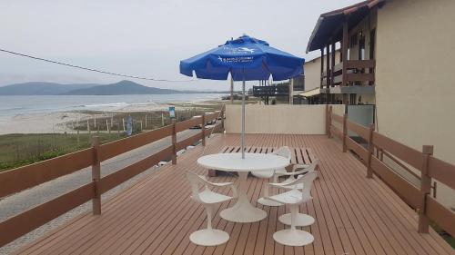 a patio with a table and chairs and an umbrella at Pousada do Albatroz in Cabo Frio