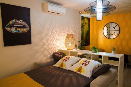 a bedroom with a bed and a desk with a lamp at MANGANAO LOFTS INN Bord de Mer in Saint-François