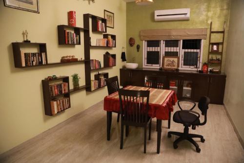 a dining room with a table and chairs and bookshelves at The Lord's Prayer in Chennai