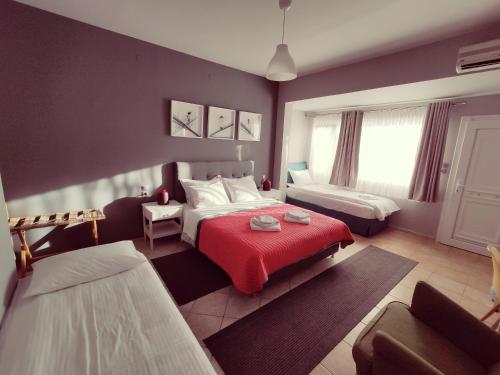 1 dormitorio con 2 camas y manta roja en Philoxenia, en Kalambaka