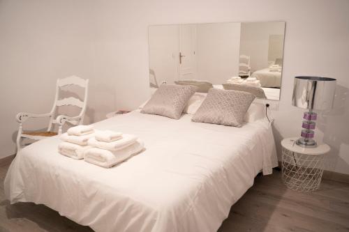 ein Schlafzimmer mit einem weißen Bett und Handtüchern darauf in der Unterkunft Apartamento turístico Calle San Basilio 6 patios in Córdoba