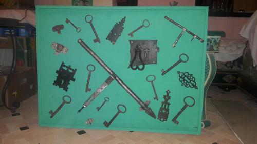 a display of old keys on a green wall at Dar Pa Labzioui in Meknès