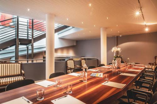 a conference room with a long wooden table and chairs at Feldmilla Design Hotel - Wellness & SPA in Campo Tures