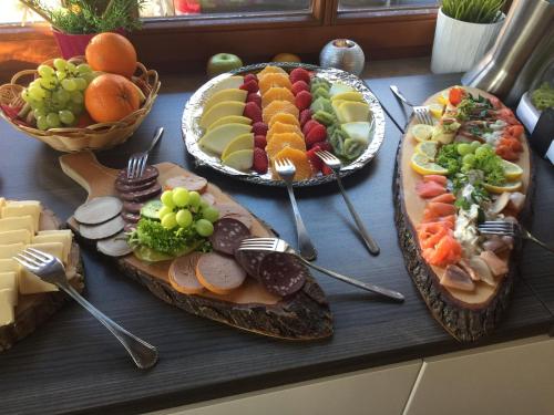 a table topped with two plates of food with forks and fruit at Landgasthaus Alter Posthof in Halsenbach
