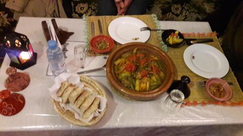 a table with a plate of food and a bowl of food at Dar Pa Labzioui in Meknès