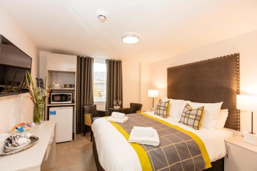 a hotel room with a large bed and a kitchen at Dalkeith ApartHotel in Dalkeith