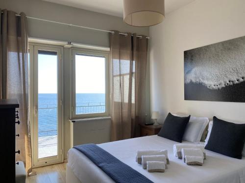 a bedroom with a bed with a view of the ocean at Casa Vitale in Aci Castello