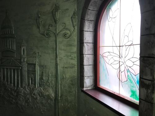 a window with a butterfly painted on a wall at Polyanskiy Zamok in Polyana