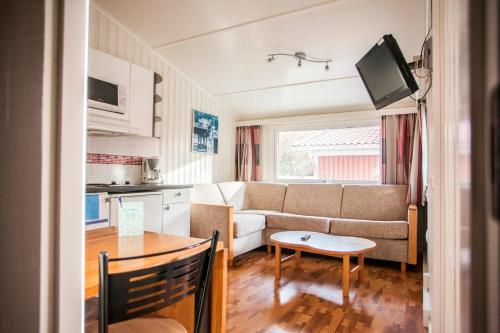a living room with a couch and a table at Lisebergsbyns Stugor in Gothenburg