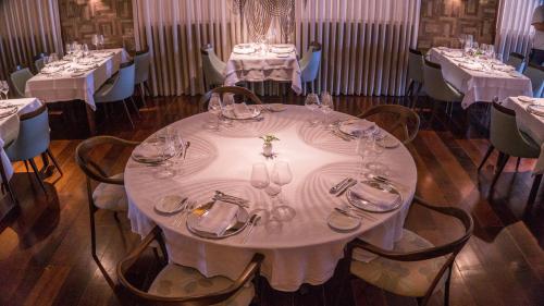 a dining room with a table with plates and glasses at Vogal Luxury Beach Hotel & SPA in Natal