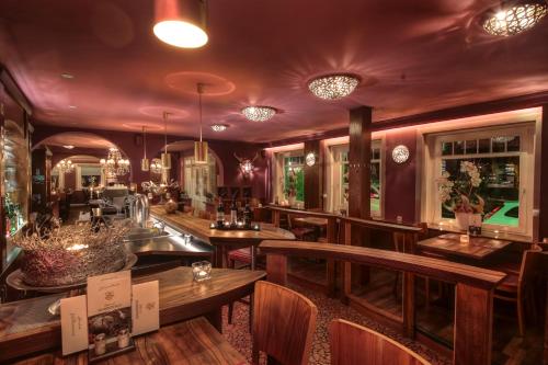 NOEL Hotel-Restaurant في سيفيتال: وجود بار بطاولات وكراسي خشبية في المطعم