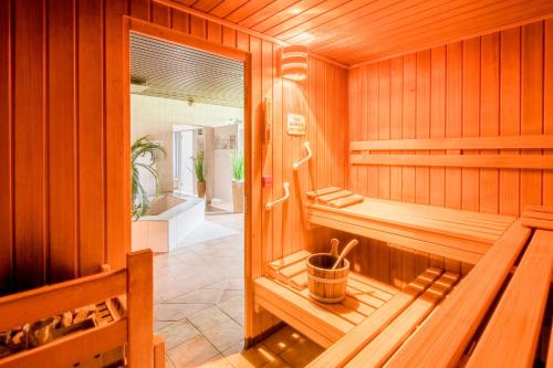 una sauna de madera con bañera y ventana en Waldhotel Schäferberg, en Espenau